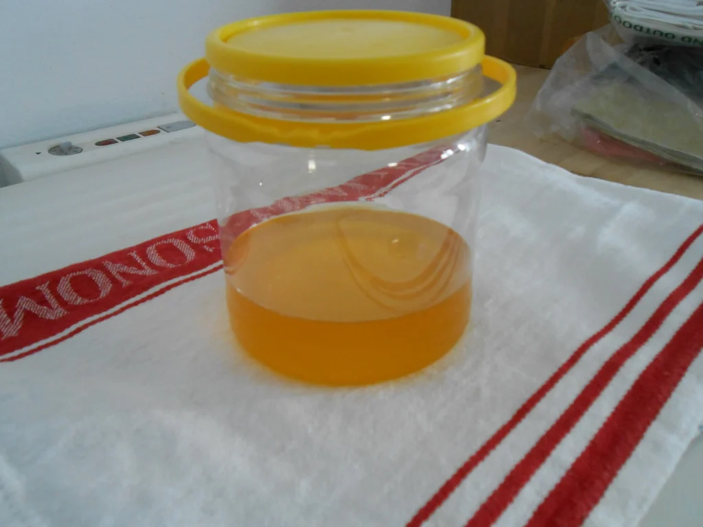 A jar of homemade ghee, golden and freshly strained, cooling on a kitchen cloth