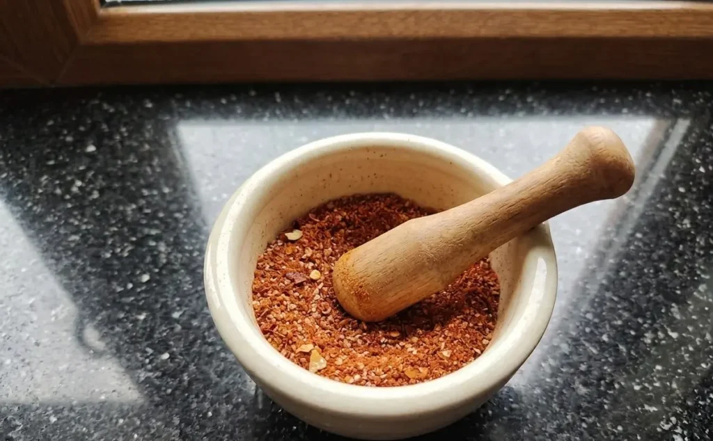 4-3-2-1 spice rub in a cream pestle and mortar on granite worktop β homemade BBQ rub β The Flexible Chef