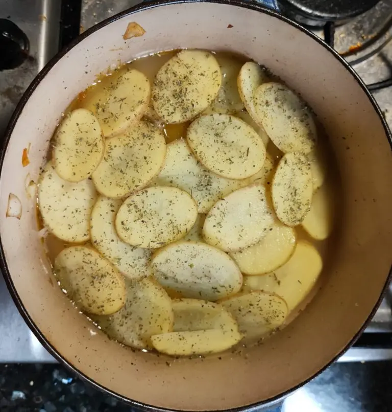 Dublin Coddle with sliced potatoes and stock in a Le Creuset, ready for the oven — Casa Adora