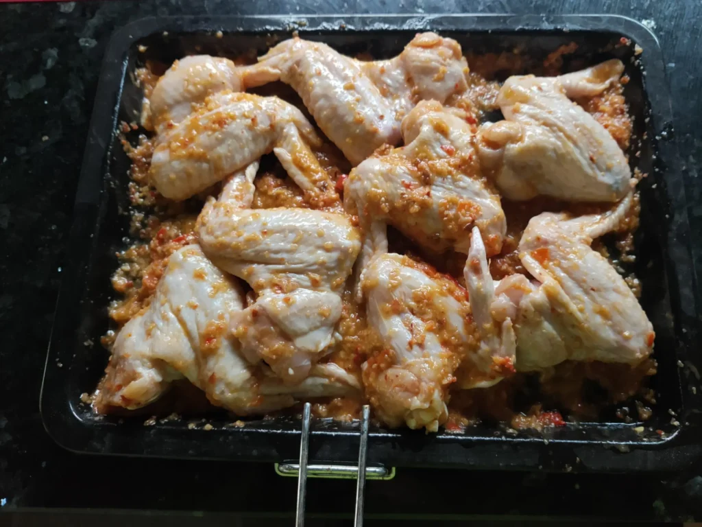 Chicken wings coated in quick red chilli sauce ready for the oven – quick red chilli sauce – The Flexible Chef