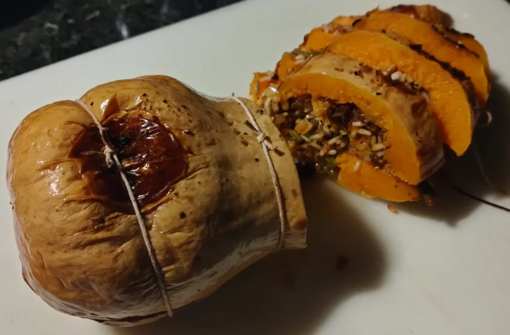 Baked stuffed butternut squash tied with string and sliced open to reveal the chorizo and rice stuffing at Casa Adora
