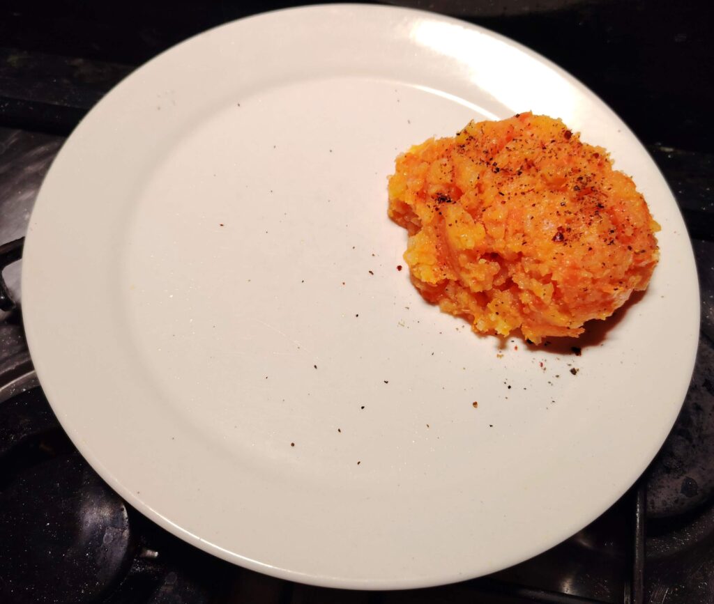 Mashed carrot and swede on a white plate.