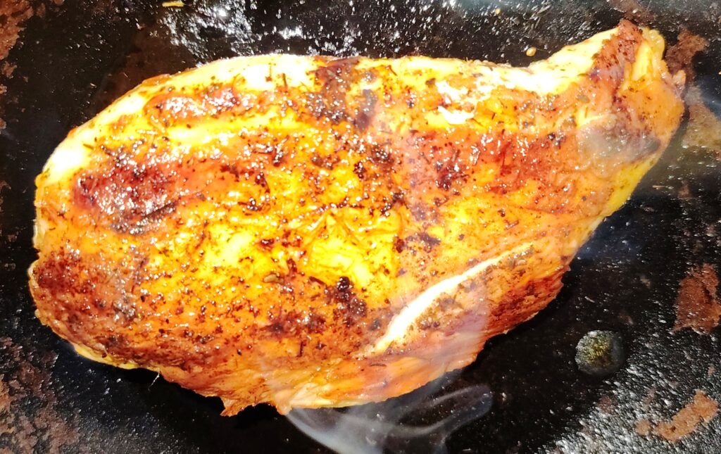 A juicy chicken breast in an oven proof skillet.