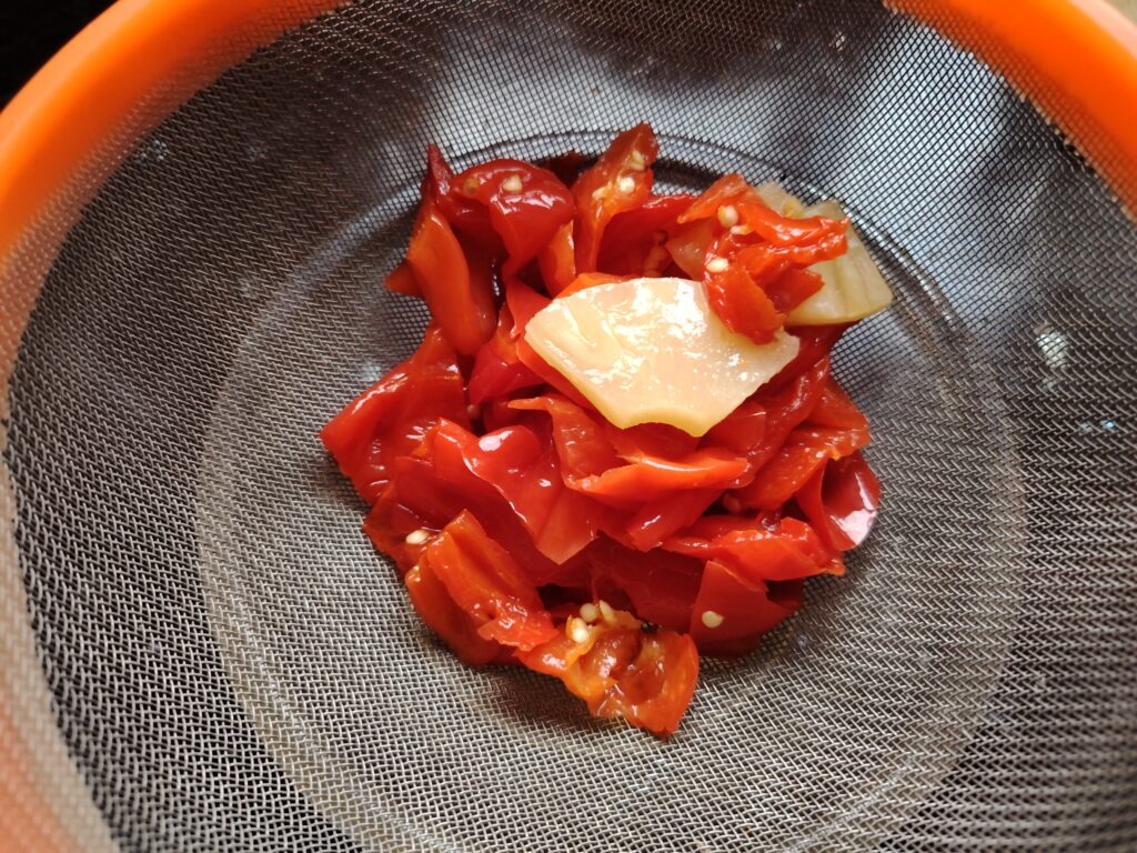 Fermented Almería red chillies drained in a sieve — ready to blend into Fruity Almería Red hot sauce