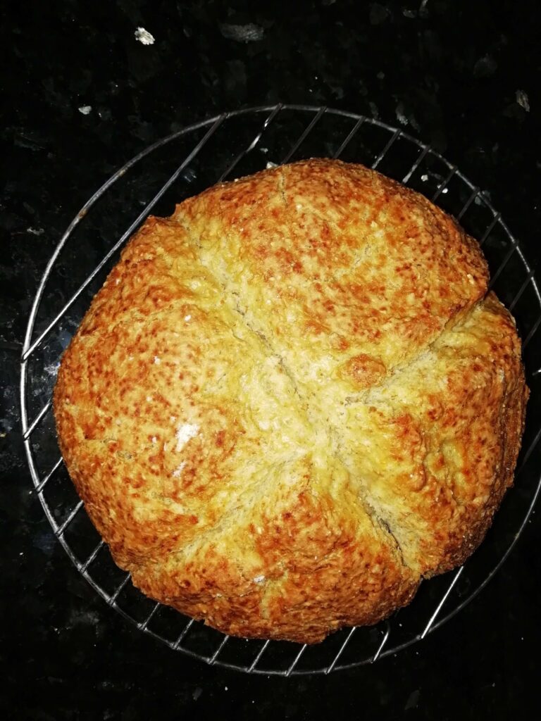 A golden butter and honey soda bread cooling on a wire rack with deep slash marks across the top – butter honey soda bread – The Flexible Chef