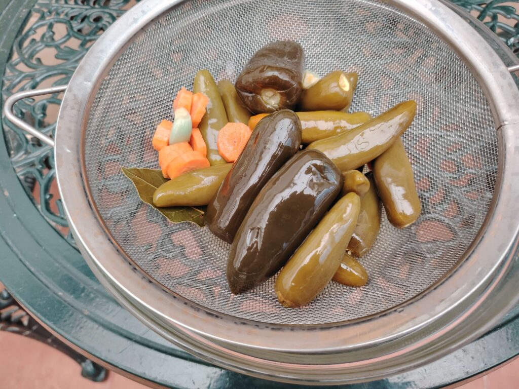 Fermented green chillies, carrot and bay leaf drained on a sieve — fermented green chilli sauce — The Flexible Chef