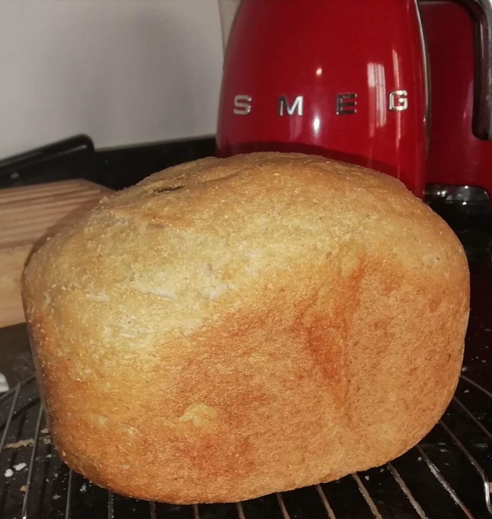 A golden Khorasan Kamut loaf cooling on a wire rack with a red Smeg toaster in the background – Khorasan Kamut loaf – The Flexible Chef