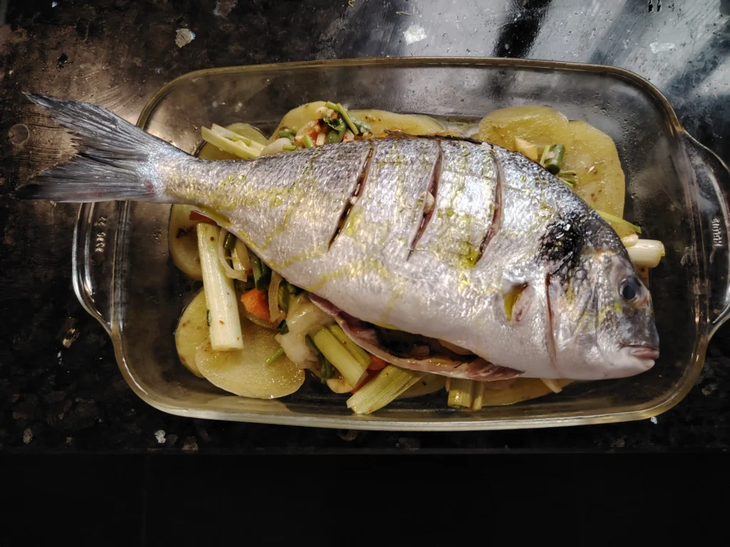 Whole dorada sea bream ready to bake over vegetables – The Flexible Chef