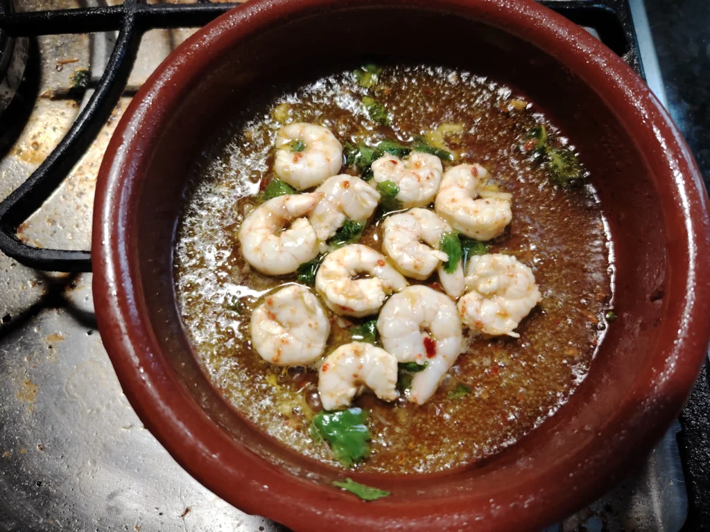 Garlic prawns warming in aceite verde in a cazuela – The Flexible Chef