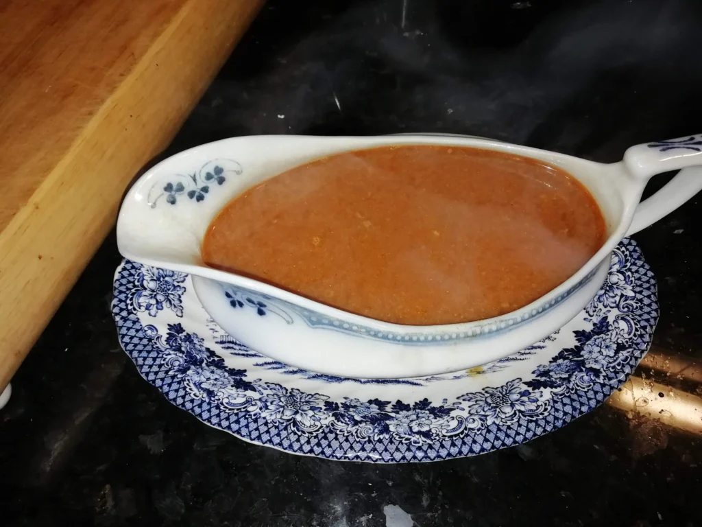 Granny's Idris pattern gravy boat filled with rich brown British gravy on the black granite worktop at Casa Adora – The Flexible Chef