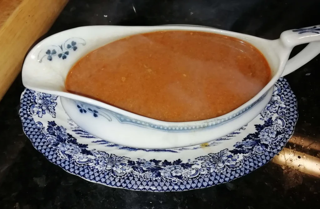 The Wolstenholme Fold Sauce — a mustard onion sauce in a vintage blue and white gravy boat on a black granite worktop, Casa Adora