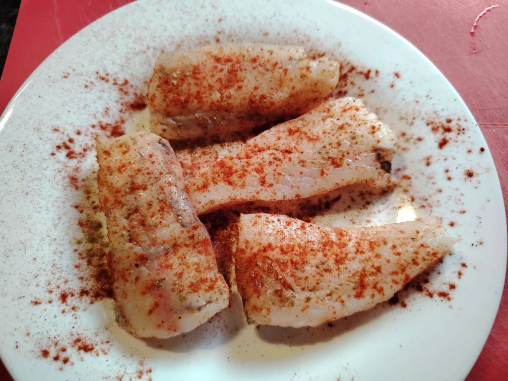 Four monkfish pieces dusted with pimentón picante, ready to griddle