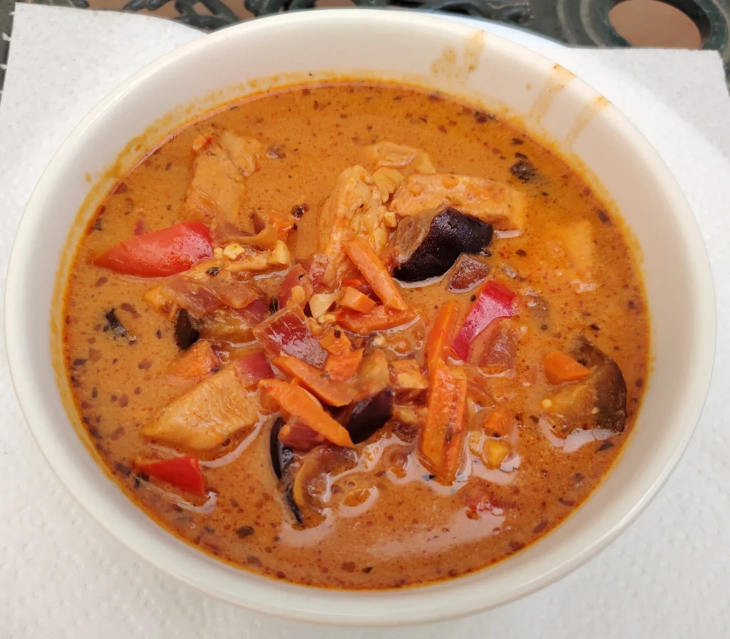 Coconut chicken and aubergine stew in a white bowl — smoked paprika broth with red pepper and carrot