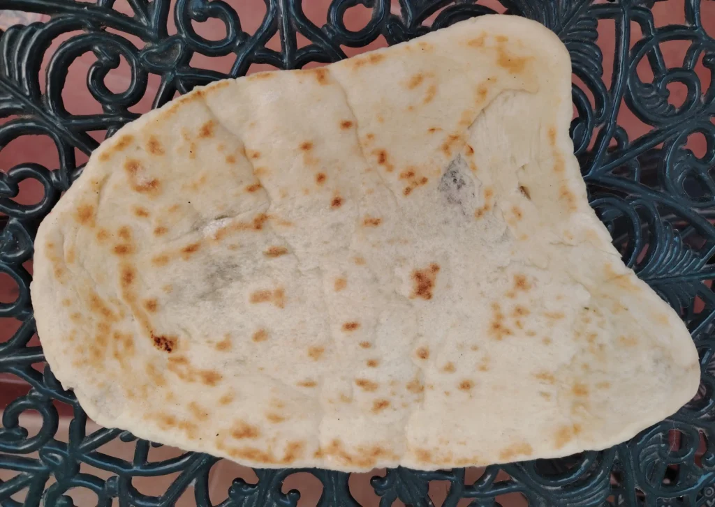 Wok-blistered kebab shop flatbread, golden and charred on the wrought iron table – kebab shop flatbread recipe – The Flexible Chef