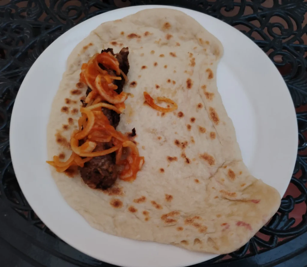 Sausage-style beef kebab wrapped in a wok-blistered flatbread with fermented hot sauce onions β sausage style beef kebab recipe β The Flexible Chef
