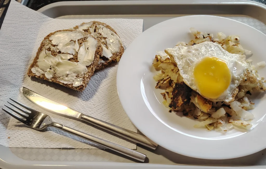Bubble and squeak with fried egg and buttered bread on a tray — bubble and squeak recipe — The Flexible Chef