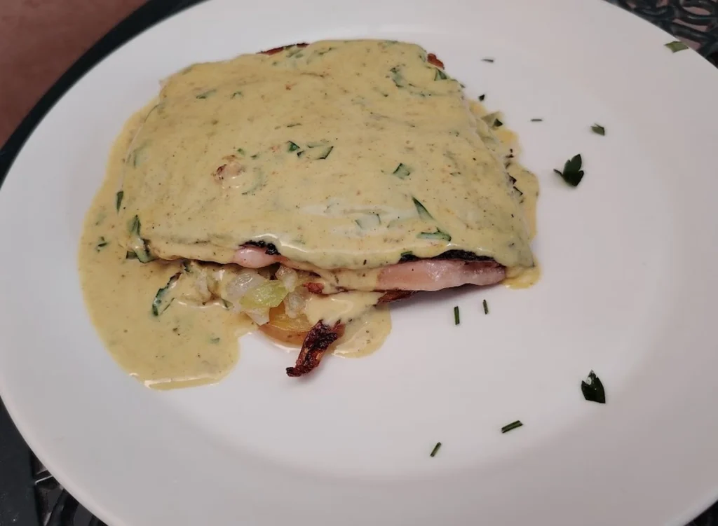 Pan-fried trout fillet with lemon cream sauce on a bed of sautéed potato and cabbage on a white plate — pan fried trout recipe — The Flexible Chef