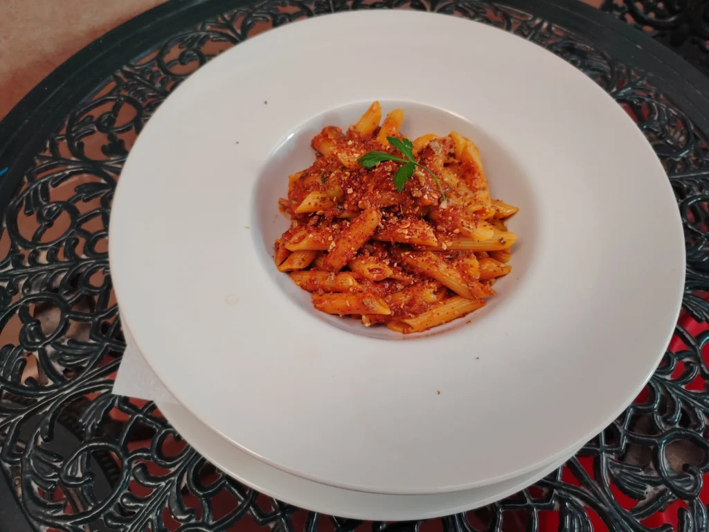 Penne rigate recipe with baby tomatoes, green olives and toasted oat crumb on the Casa Adora internal patio — The Flexible Chef