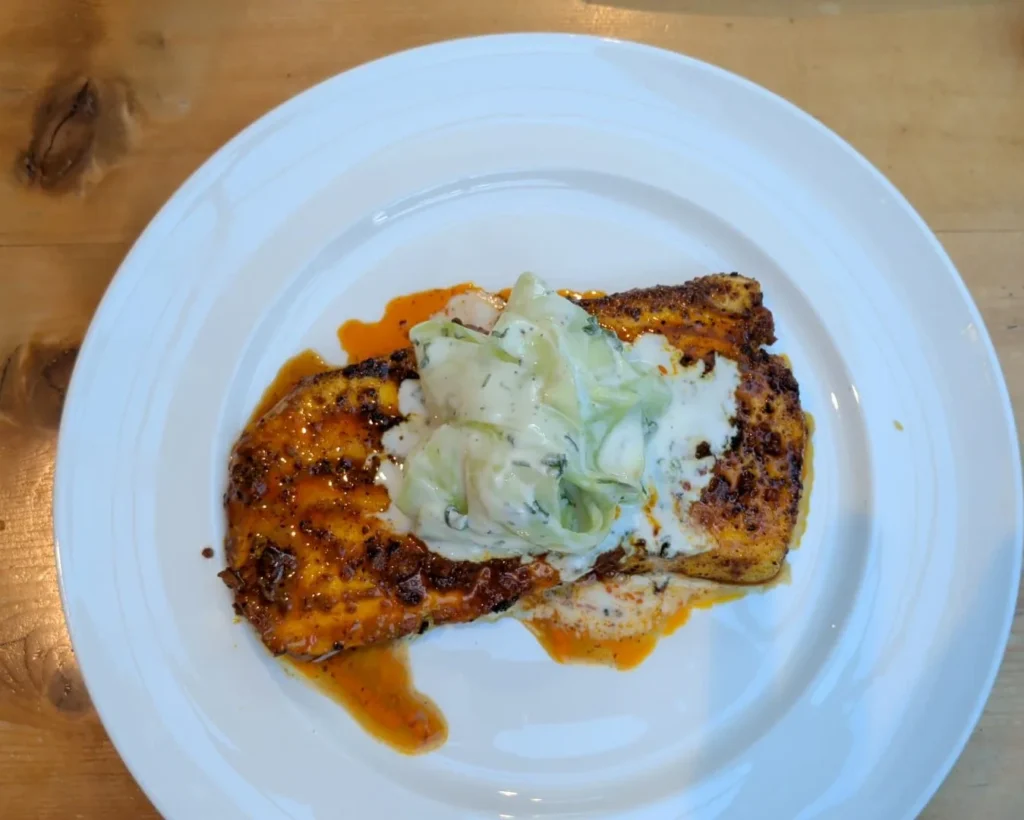 Danny's tandoori halibut with cucumber and herb yoghurt dressing on a white plate — tandoori halibut recipe — The Flexible Chef