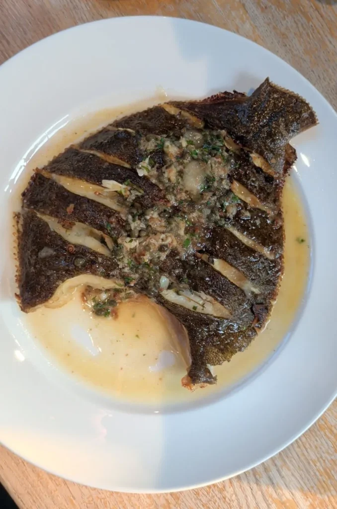 Danny's whole turbot with capers and parsley on a white plate β whole turbot recipe β The Flexible Chef