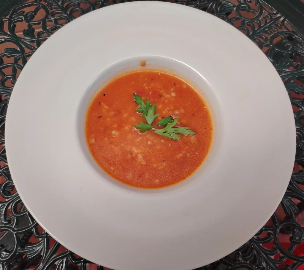 High fibre diet plan — red lentil dhal with pearl barley in a wide white bowl on the Casa Adora patio table, garnished with fresh parsley