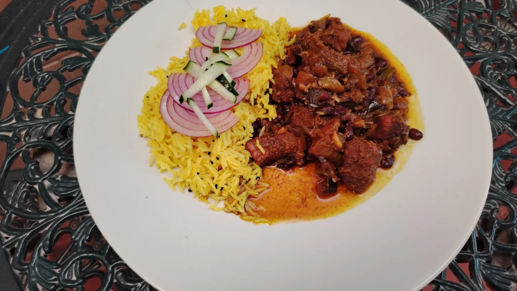Slow cooker beef curry Kerala style with black beans, served with turmeric basmati rice, red onion rings and cucumber julienne